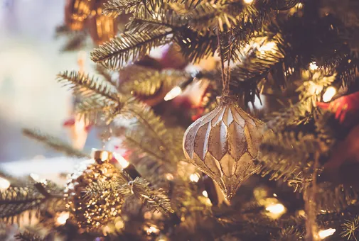 Décorations dorées et guirlande lumineuse dans un sapin